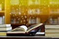 Open book with the notebook Laptop on the table and English alphabet Floating above the book in the library and blur bookshelf