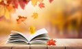 open book and falling autumn leaves