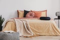 Open book on patterned pouf in colorful bedroom interior