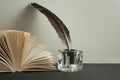 Open book and quill pen with inkwell on wooden table. Free copy space. Royalty Free Stock Photo