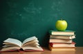 Open book rests on table next to stack of textbooks topped with green apple. Dark green chalkboard background suggests classroom Royalty Free Stock Photo