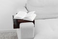 Open book on sofa with wooden armrest table indoors. Interior element Royalty Free Stock Photo