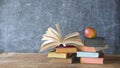 Open book and stack of books with chalk board and red apple.Back to school, education, learn concept. Royalty Free Stock Photo