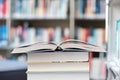 Open book on a stack of books in a library