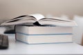 Open book on a stack of books on a table