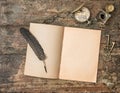 Open book and vintage writing accessories. Textured wooden background Royalty Free Stock Photo