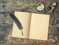 Open book and vintage writing accessories. Wooden texture backgr Royalty Free Stock Photo