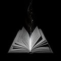 Open book with water droplets falling from above Royalty Free Stock Photo