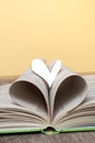 An open book with a wooden heart on the table. Concept Love for reading, books. Library, education. Closeup copy space Royalty Free Stock Photo