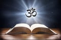 Open book on wooden table and hindu symbol front view