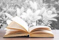 Open book on wooden table on natural background