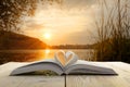 Open book on wooden table on natural blurred background. Heart book page. Back to school. Copy Space