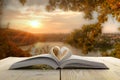 Open book on wooden table on natural blurred background Royalty Free Stock Photo