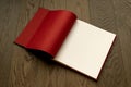 Open book on wooden table with red and white empty pages. Royalty Free Stock Photo