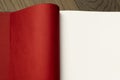 Open book on wooden table with red and white empty pages. Royalty Free Stock Photo