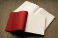 Open book on wooden table with red and white empty pages. Royalty Free Stock Photo