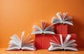 Open books with pages displayed on an orange background. Stack of red books under them create a base. Education reading concept Royalty Free Stock Photo