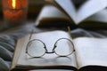 Open Books, Reading Glasses and Lit Candle Royalty Free Stock Photo