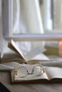 Open Books, Reading Glasses and Lit Candle Royalty Free Stock Photo