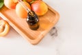 an open bottle with a dropper of cosmetic organic oil apricot on a tray wooden of fruity for face and body skin care Royalty Free Stock Photo