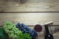 Open bottle of red wine with a glass, corkscrew and ripe grape on a wooden background. Copy space. Royalty Free Stock Photo