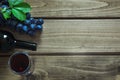 Open bottle of red wine with a glass, corkscrew and ripe grape on a wooden board. Copy space and top view. Royalty Free Stock Photo