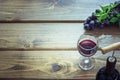 Open bottle of red wine with wineglass, corkscrew and ripe grape on wooden board. Copy space and top view. Royalty Free Stock Photo