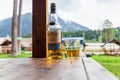 An open bottle of single malt whiskey Glen Livet founder`s reserve stand in a wooden gazebo against mountains