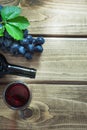 Open bottle, wineglass with red wine, corkscrew and ripe grape on wooden board. Copy space and top view Royalty Free Stock Photo