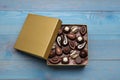 Open box of delicious chocolate candies on light blue wooden table, top view Royalty Free Stock Photo