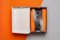 Open box with new sneakers over orange gray background