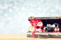 Open briefcase with old camera and christmas decoration over bokeh blurred background