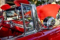 Open bright red vintage retro convertible car with chrome details and moldings exhibited at a provincial town street exhibition Royalty Free Stock Photo