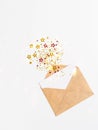 Open brown envelope with blank white card and various stars with imitation of explosion Royalty Free Stock Photo