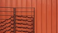 Open brown folding metal garage gate on orange corrugated steel wall