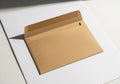 An open brown Kraft paper envelope on a white surface, casting a shadow. The rectangular envelope Royalty Free Stock Photo