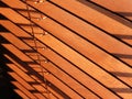 Open brown wooden blinds, with sunlight shining through