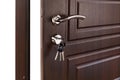 Open brown wooden door handle with lock. Royalty Free Stock Photo