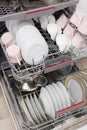 Open built-in dishwasher with clean dishes in white kitchen Royalty Free Stock Photo