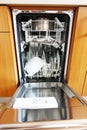 Open built-in dishwasher machine with clean dishes inside