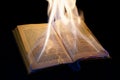 Open burning book with black background
