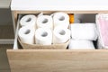 Open cabinet drawer with toilet paper rolls