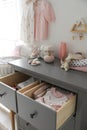 Cabinet drawers with baby clothes and shoes in child room Royalty Free Stock Photo