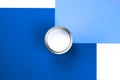 An open can of white paint on a white and blue background Royalty Free Stock Photo