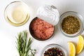 Open canned tuna. White background. Radom spices, herbs. Preparing appetizers