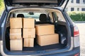 Open car trunk with moving boxes outdoors. Boxes and packages stacked inside car, ready for relocation. Delivery service, moving Royalty Free Stock Photo