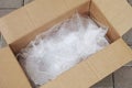 An open cardboard box with bubble wrap inside of it lying on tiles Royalty Free Stock Photo