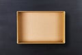 Open cardboard box on chalkboard background. Empty cardboard package on black texture