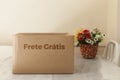 Detail of a cardboard box written on frete gratis.