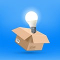 Open cardboard box with a glowing idea light bulb